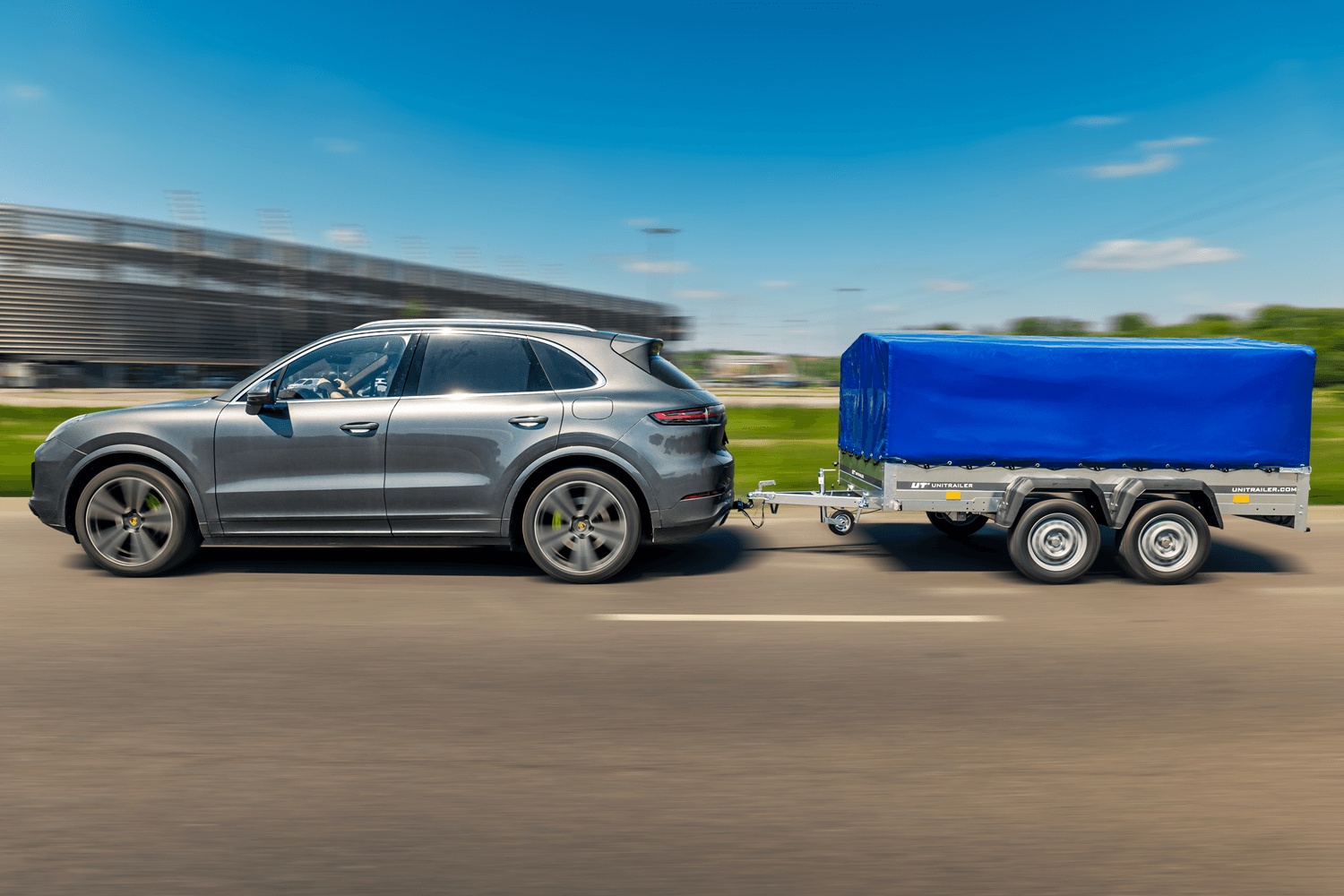 Ein Porsche zieht einen Anhänger mit montiertem blauen Rahmen.