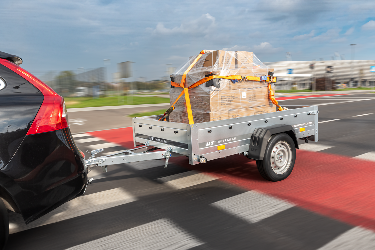 Ein Auto, das einen silbernen Anhänger voller Kisten zieht